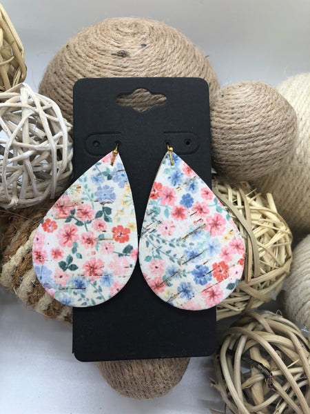Blue pink and coral flowers on white cork
